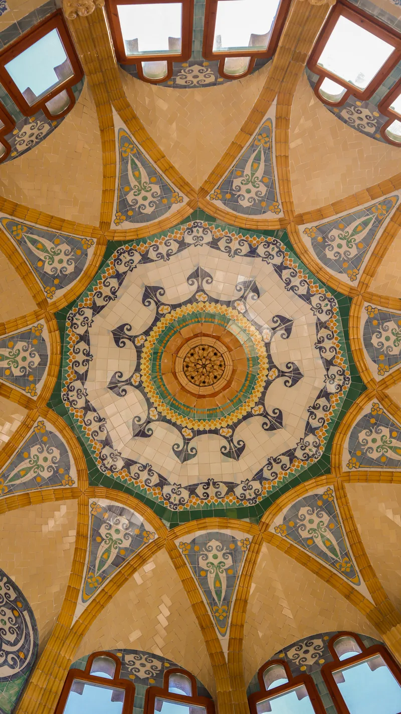 A colourful tiled ceiling with geometric patterns around a central rosette