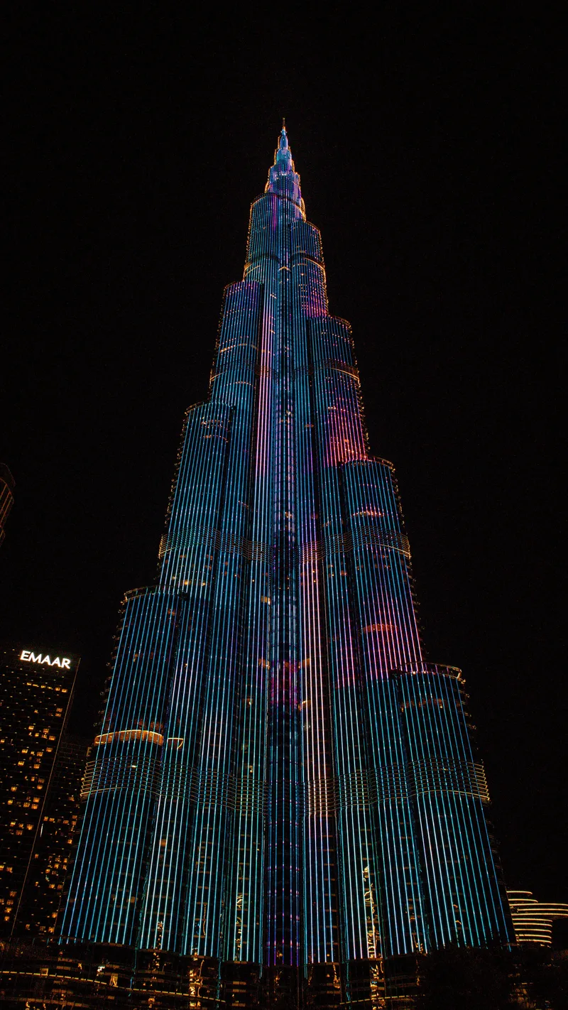 The Burj Khalifa lit up in colour against the night sky