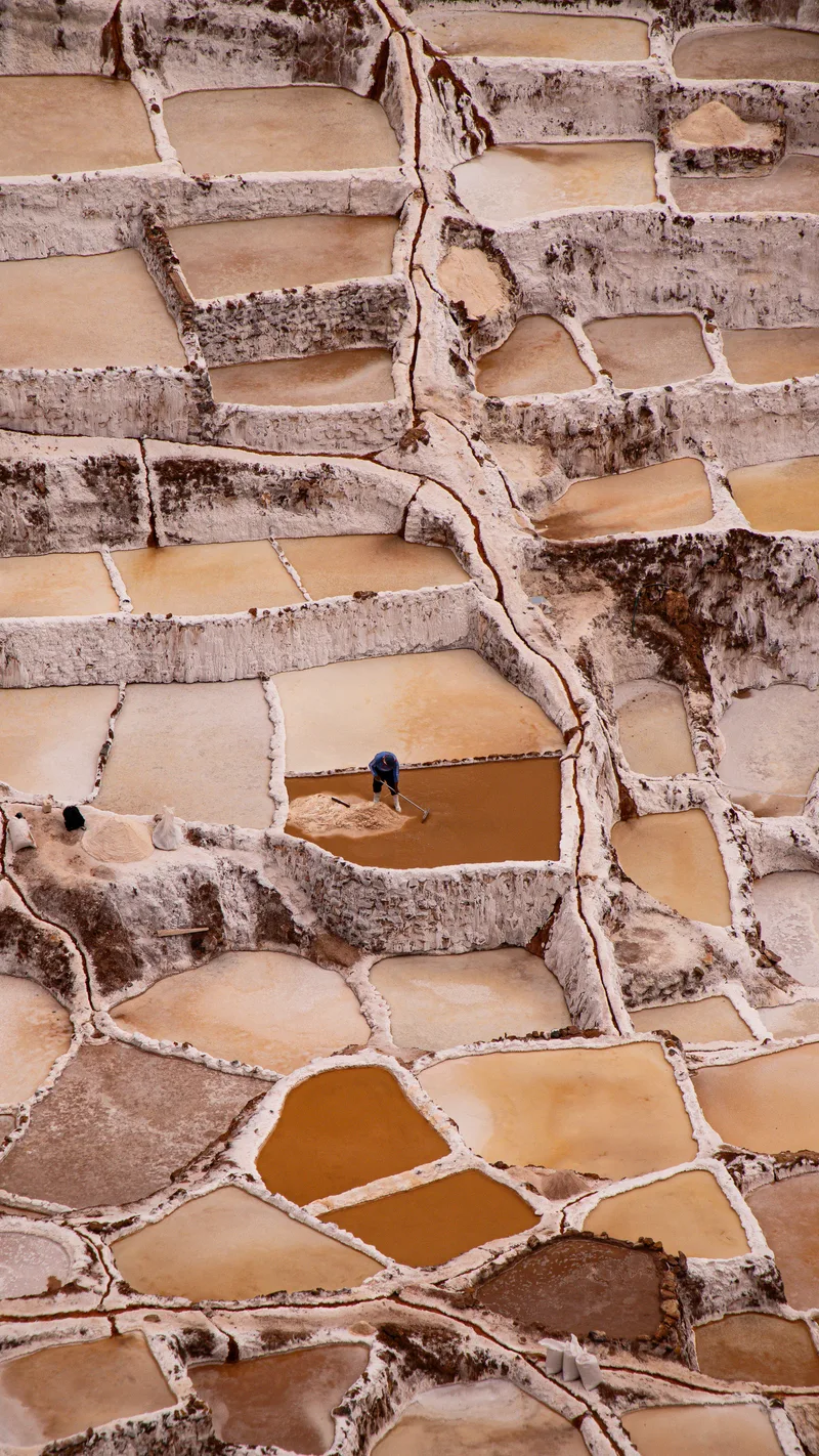 A worker among the terraced salt pans of Maras