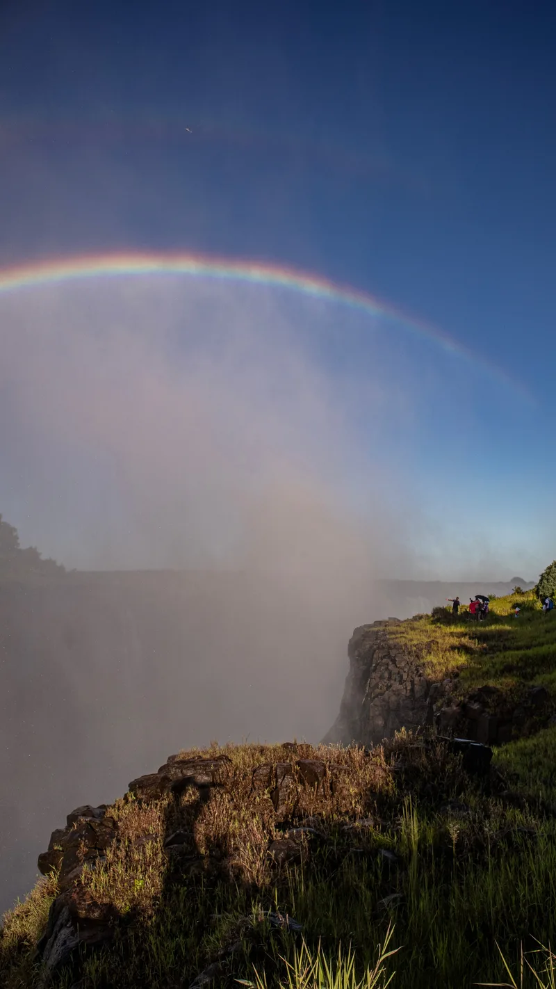 A rainbow in the spray above the edge of the gorge